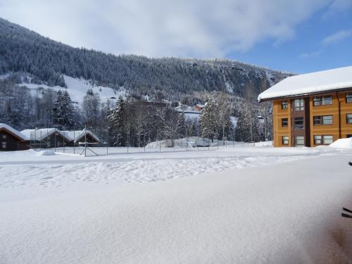 a snow covered parking lot in front of a building at Actif 106 - Hallingheim apartment ski inn/ski ut in Ål
