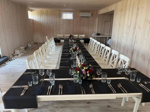 a long table in a room with tables and chairs at Arklių Pašto Stotis 
