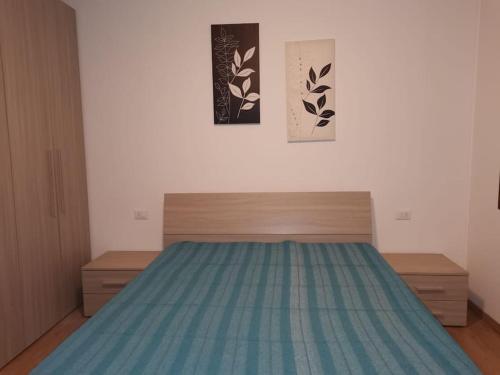 1 dormitorio con 1 cama con colcha azul en Casa della nonna, en Chioggia