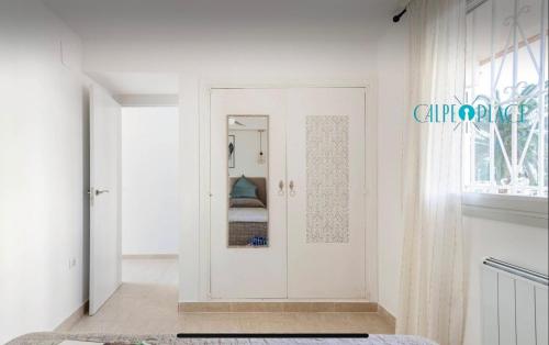 um quarto com uma porta com um espelho em AZAFRAN apartamento para descanso cerca de la playa em Calpe