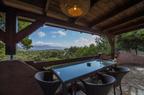 a table and chairs on a porch with a view at Hotel Les Hauts de Porto-Vecchio in Porto-Vecchio