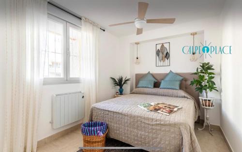 um quarto com uma cama e uma ventoinha de tecto em AZAFRAN apartamento para descanso cerca de la playa em Calpe