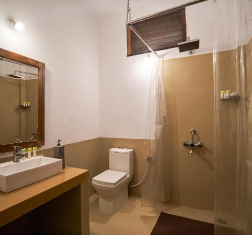 a bathroom with a toilet and a sink and a shower at Bagh Tola, Bandhavgarh Tiger Reserve in Tāla