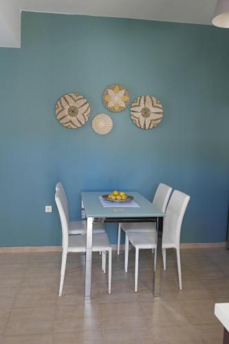 a dining room table with chairs and a blue wall at Country Bellavista Darmarohori in Darmarochori