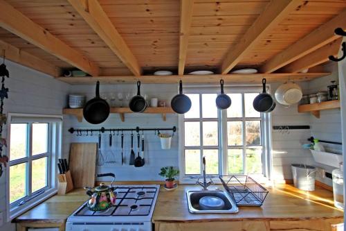 cocina con fogones y algunas ollas y sartenes en Tiny House on isolated farm by the Cornish Coast en Bude