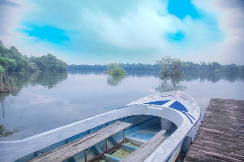 a boat is docked at a dock on a lake at Bentota River Villa in Bentota