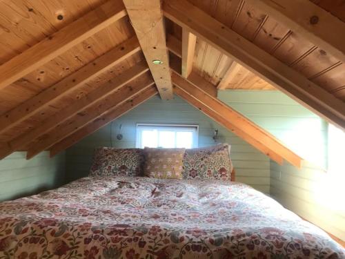 a bed in a room with an attic at Tiny House on isolated farm by the Cornish Coast in Bude