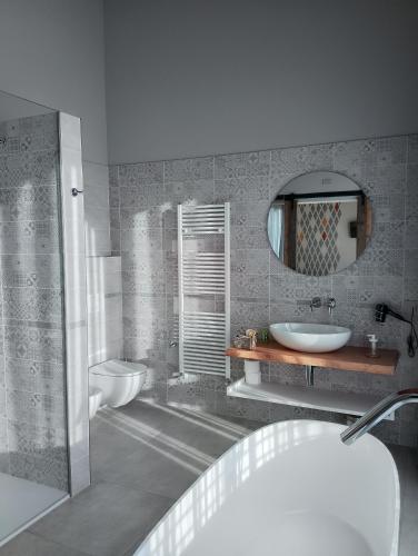 a bathroom with a tub and a sink and a mirror at B&B LA VALLUNA in Erbusco