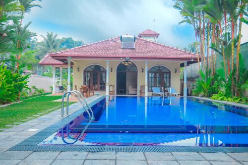 a swimming pool in front of a house at Bentota River Villa in Bentota