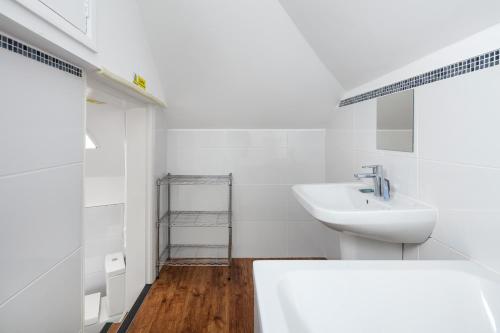 La salle de bains blanche est pourvue d'un lavabo et de toilettes. dans l'établissement Castle Properties: The Duchess, 3 Bed Family cottage, à Windsor