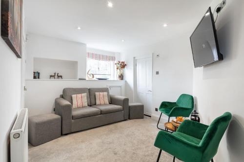 a living room with a couch and two green chairs at Castle Properties: The Duchess, 3 Bed Family cottage in Windsor