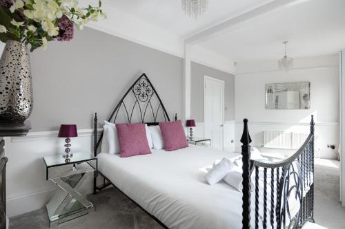 a bedroom with a black and white bed with pink pillows at Castle Properties: The Duchess, 3 Bed Family cottage in Windsor