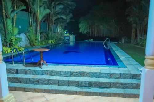 a swimming pool in a yard with a table next to it at Bentota River Villa in Bentota