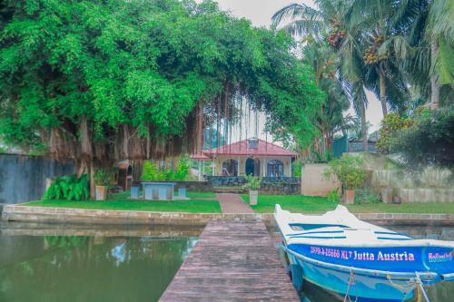 a boat docked at a dock in front of a house at Bentota River Villa in Bentota