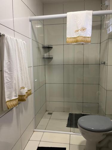 a bathroom with a shower with a toilet and towels at Flat JK 101 in Juazeiro do Norte