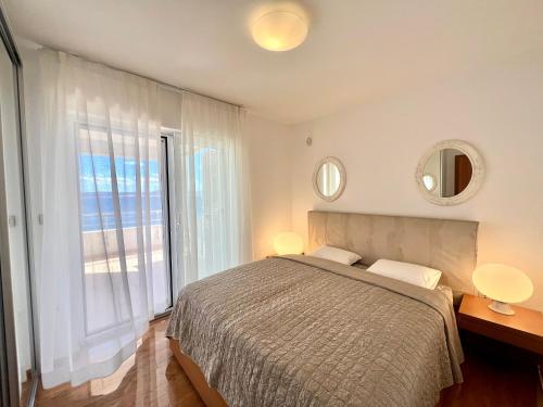 - une chambre avec un lit et une grande fenêtre dans l'établissement Apartment Golden View Dramalj, à Dramalj