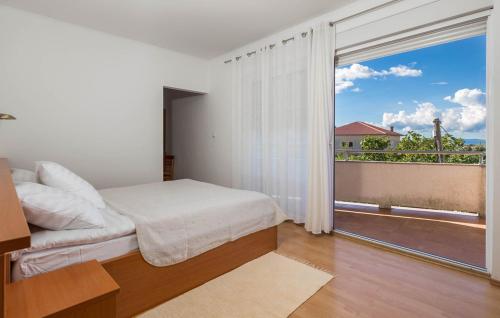 a bedroom with a bed and a large window at Apartments Dedić in Supetarska Draga
