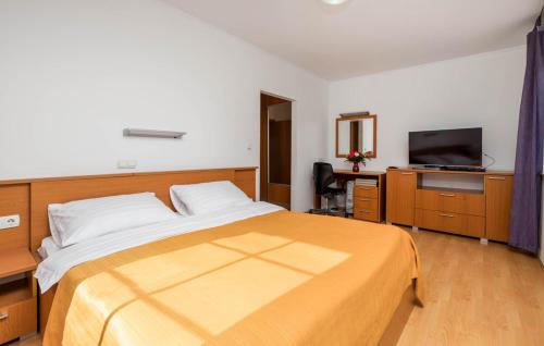 a bedroom with a large bed and a television at Apartments Dedić in Supetarska Draga
