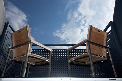 two wooden chairs sitting on top of a building at Der Wilhelmshof in Vienna