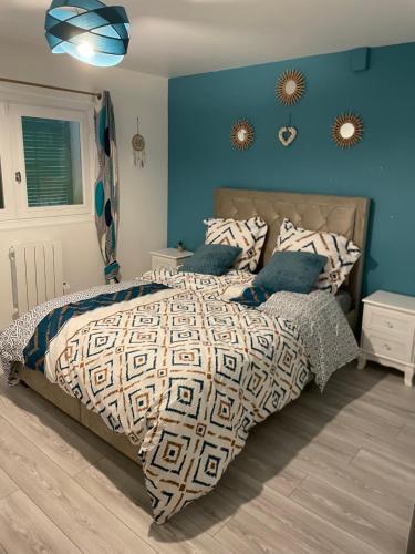1 dormitorio con 1 cama grande y paredes azules en Chez Julie petit appartement une chambre rez jardin maison, en Tulle