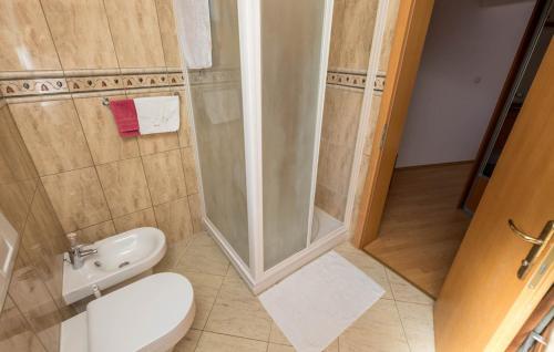 a bathroom with a shower and a toilet and a sink at Apartments Dedić in Supetarska Draga