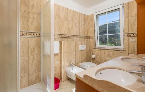 a bathroom with a sink and a toilet and a window at Apartments Dedić in Supetarska Draga