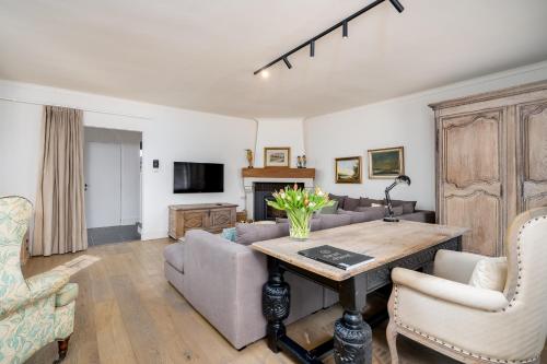 a living room with a table and a couch at CAPRINO Guesthouse in Knokke-Heist