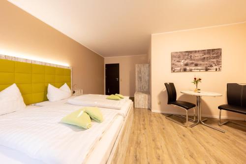 シュネーヴァーディンゲンにあるHotel Ehlersのベッド2台とテーブルが備わるホテルルームです。