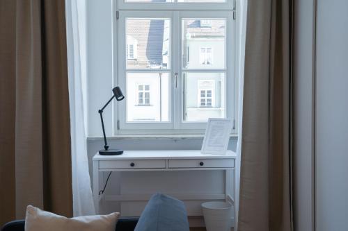 una ventana con un escritorio con una lámpara delante en Maximilianstraße, en Augsburg