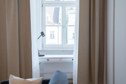 Cette chambre dispose d'une fenêtre avec une lampe et un canapé. dans l'établissement Maximilianstraße, à Augsbourg