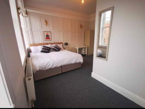 a small bedroom with a bed and a mirror at Wardwick Guest House in Derby