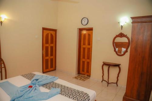 a bedroom with two beds and a clock on the wall at Bentota River Villa in Bentota