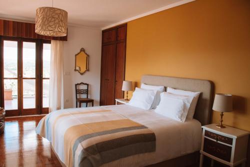 a bedroom with a large bed with a yellow wall at Just Like Home - Casa do Rosmaninho in Caminha