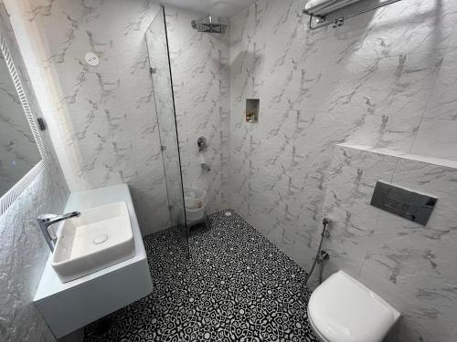 een witte badkamer met een wastafel en een toilet bij The Warrick Homestay, A Luxe Stay Near Mall Road, Shimla in Shimla