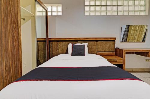 a bedroom with a large white bed and a desk at SUPER OYO Collection O 92277 Setra Priangan Guest House in Bandung