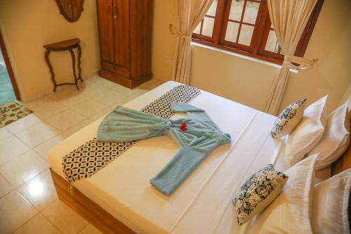 a white bed with a bow on top of it at Bentota River Villa in Bentota