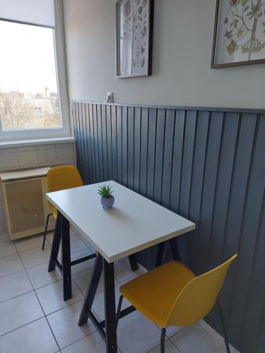 einen weißen Tisch und zwei Stühle in einem Zimmer in der Unterkunft Olaszrizling Apartman in Veszprém