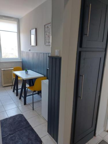 a room with a table and a black door at Olaszrizling Apartman in Veszprém