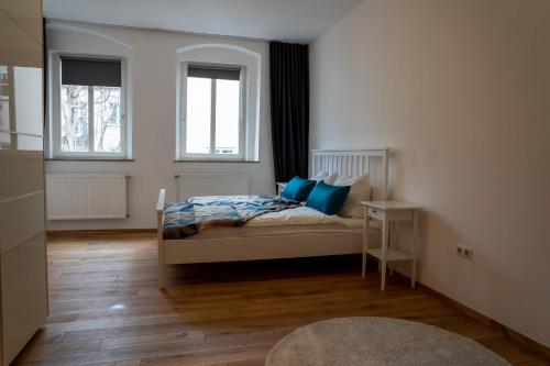 ein Schlafzimmer mit einem Bett mit blauen Kissen in der Unterkunft Altstadtjuwel Liboria in Augsburg