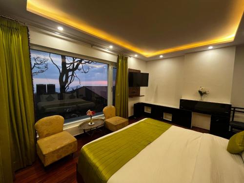 een slaapkamer met een bed en een groot raam bij The Warrick Homestay, A Luxe Stay Near Mall Road, Shimla in Shimla
