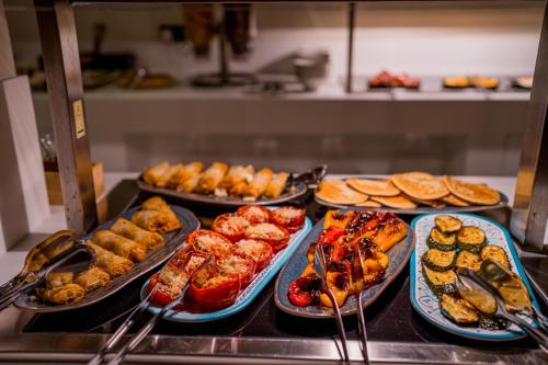a buffet line with different types of food on plates at Moon Hotel & SPA. in Aguadulce