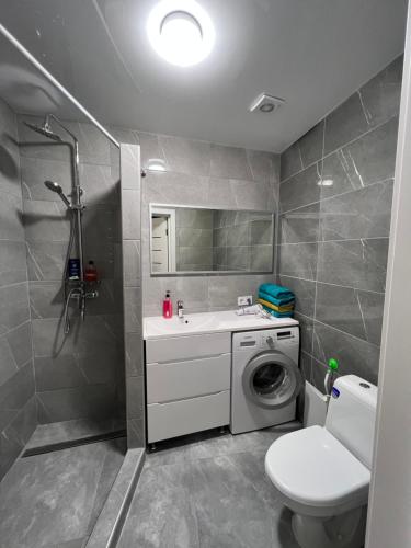 ein Badezimmer mit einer Waschmaschine und einem Waschbecken in der Unterkunft Kulisha 2bedroom apartment near Opera House with balcony in Lwiw