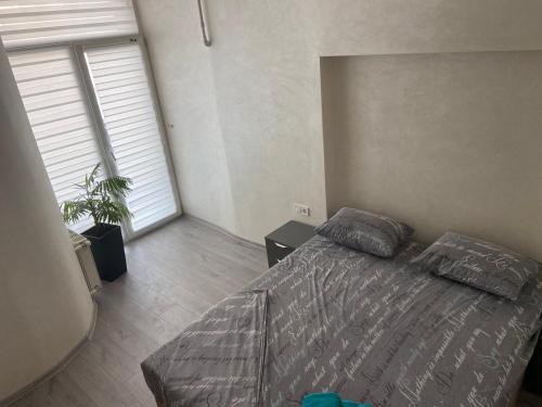 ein Schlafzimmer mit einem Bett und einem großen Fenster in der Unterkunft Kulisha 2bedroom apartment near Opera House with balcony in Lwiw