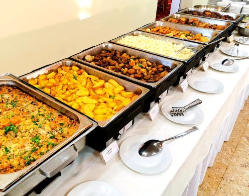 a buffet with many trays of food on a table at Hotel Montana - Covasna in Covasna