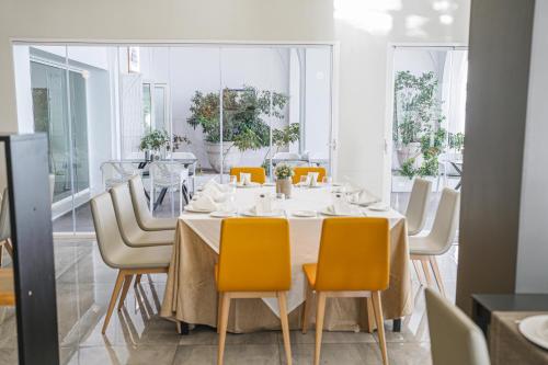 a dining room with a white table and yellow chairs at Moon Hotel & SPA. in Aguadulce
