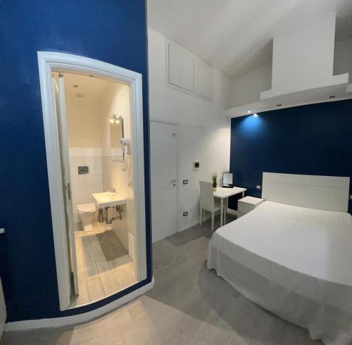 a bedroom with a white bed and a blue wall at Boutique Rooms in Rome