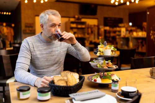 a man sitting at a table eating food at Hotel Ehlers in Schneverdingen