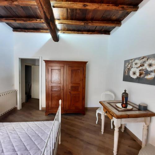 1 dormitorio con cama, mesa y techos de madera en La casa nel vicolo, en Bracciano