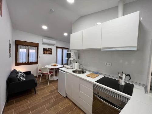 a kitchen with white cabinets and a living room at Atico El Lagar de Labastida in Labastida
