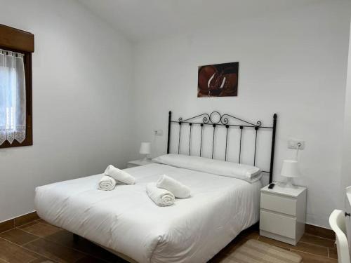 a bedroom with a white bed with two pillows on it at Atico El Lagar de Labastida in Labastida